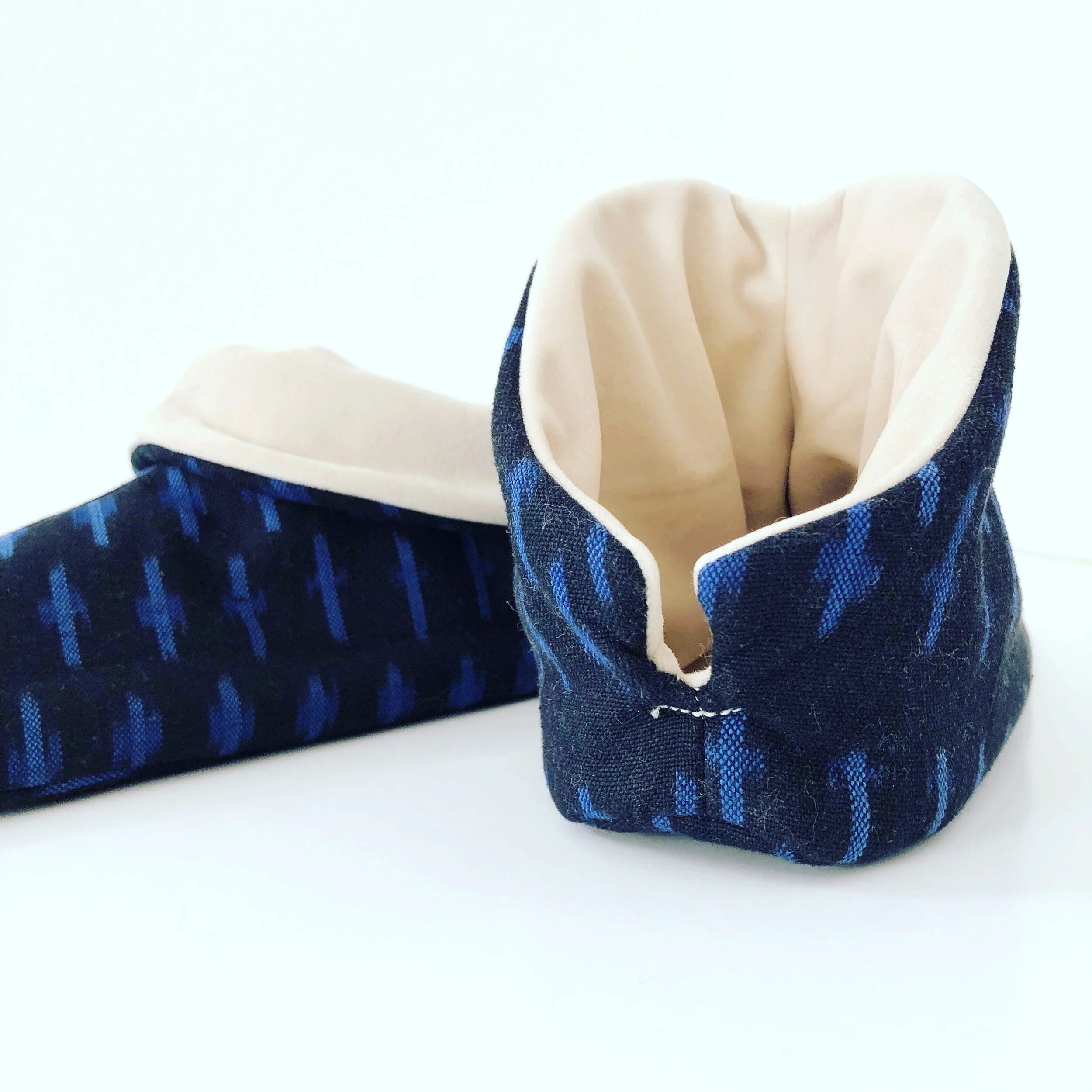 Cozy Slipper sewing pattern Pair of blue ikat slippers with white lining on a white background