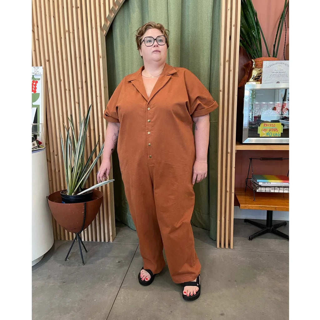 Bumper Jumper sewing pattern — plus size woman wearing a loose-fit orange woven jumper with side pockets, front buttons and roll-up sleeves, front relaxed view