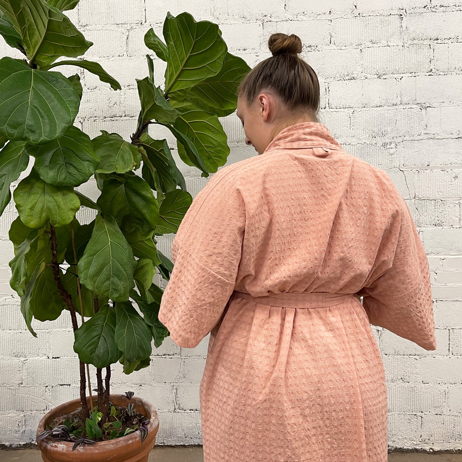 Slow Robe sewing pattern — model wearing knee-length robes with kimono sleeves, tie waist, and patch pockets; pink waffle fabric (left) and pink waffle fabric (right), back view