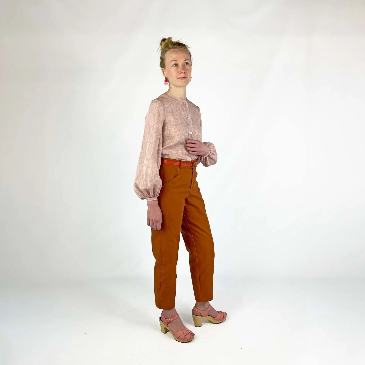 Gable Shirt sewing pattern — model wearing a button-front blouse in blush linen with voluminous bishop sleeves, gathered cuffs, and collarless neckline, side view