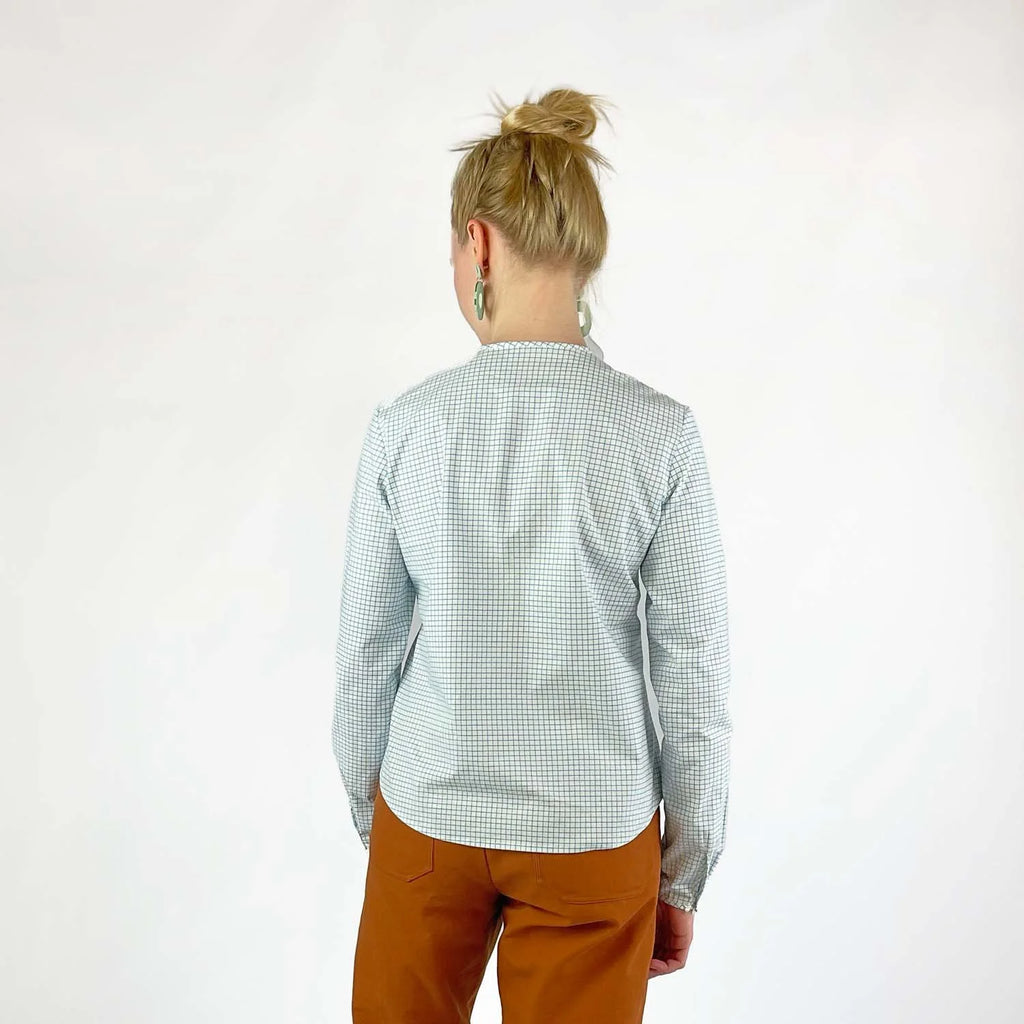 Gable Shirt sewing pattern — model wearing a button-front blouse in a grid paper patterned fabric with long sleeves sleeves and collarless neckline, back view