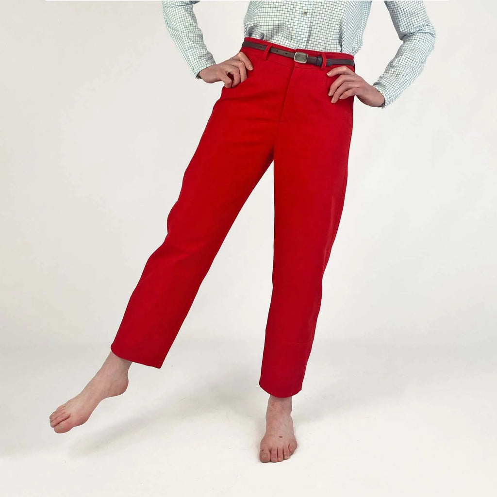 Shop Pant sewing pattern — model wearing high-waisted barrel leg pant in red herringbone twill with front pockets and belt, second front view