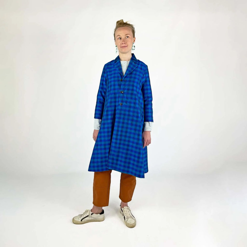 Swing Coat sewing pattern — model wearing an A-line swing coat in blue gingham with notched lapel, three-quarter sleeves, and gold buttons, front view