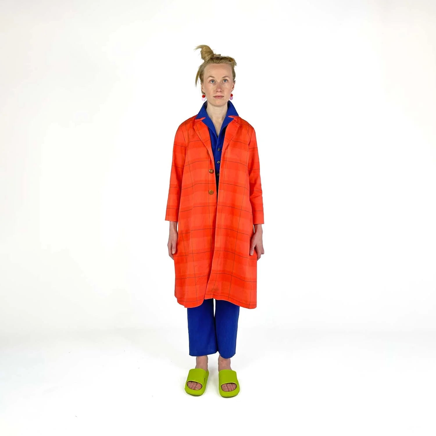 Swing Coat sewing pattern — model wearing an A-line swing coat in bold orange plaid with notched lapel, three-quarter sleeves, and gold buttons, front view