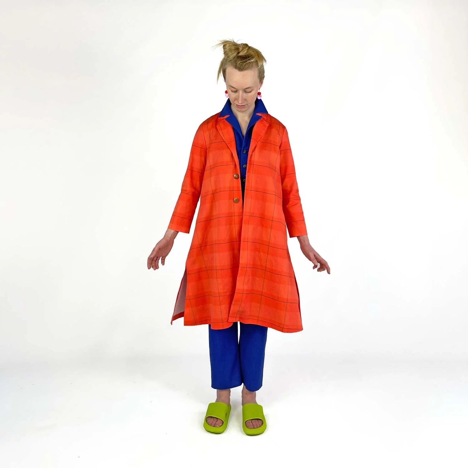 Swing Coat sewing pattern — model wearing an A-line swing coat in bold orange plaid with notched lapel, three-quarter sleeves, and gold buttons, main view
