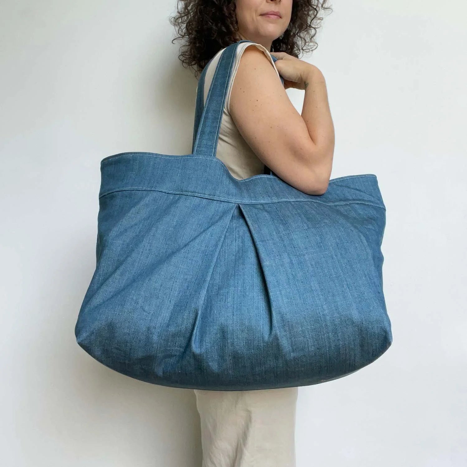 Yard Bag sewing pattern — large handmade denim tote bag with box pleat, front exterior pocket, and double shoulder straps, over the shoulder view
